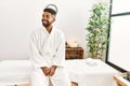 Young african american man smiling happy sitting on massage table at beauty center Royalty Free Stock Photo