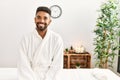 Young african american man smiling happy sitting on massage table at beauty center Royalty Free Stock Photo