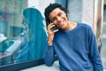 Young african american man smiling happy talking on the smartphone leaning on the wall Royalty Free Stock Photo