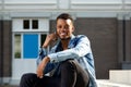Young african american man smiling outside with cellphone Royalty Free Stock Photo