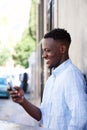 Young african american man standing outside looking at cell phone Royalty Free Stock Photo