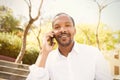 Young african american man in sun glasses with mobile phone in city garden park. Royalty Free Stock Photo