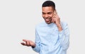 Young African American man talking on cellphone to his friend, looking cheerful and happy, posing on white studio background. Royalty Free Stock Photo