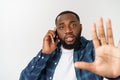 A young African American man talking on his cellular phone with a concerned or serious look on his face Royalty Free Stock Photo