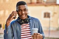 Young african american man talking on the smartphone drinking coffee at the city Royalty Free Stock Photo