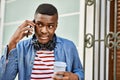 Young african american man talking on the smartphone drinking coffee at the city Royalty Free Stock Photo