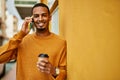 Young african american man talking on the smartphone drinking coffee at the city Royalty Free Stock Photo