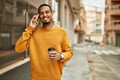 Young african american man talking on the smartphone drinking coffee at the city Royalty Free Stock Photo