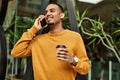 Young african american man talking on the smartphone drinking coffee at the city Royalty Free Stock Photo