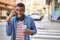 Young african american man talking on the smartphone drinking coffee at the city Royalty Free Stock Photo