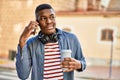 Young african american man talking on the smartphone drinking coffee at the city Royalty Free Stock Photo