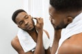 Man looking in mirror after shower in bathroom Royalty Free Stock Photo