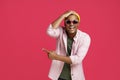 Young african american man in UK, Britain flag sunglasses, wearing casual pointing sideways excited or shocked touching Royalty Free Stock Photo