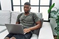 Young african american man using laptop at home sitting on the sofa depressed and worry for distress, crying angry and afraid Royalty Free Stock Photo