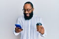 Young african american man using smartphone and drinking a cup of coffee smiling and laughing hard out loud because funny crazy Royalty Free Stock Photo