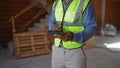 Young african american man using tablet at construction site wearing reflective vest Royalty Free Stock Photo