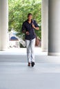 Young african american man walking with mobile phone and bag Royalty Free Stock Photo