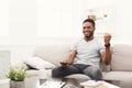 Happy man watching tv using remote controller in living room Royalty Free Stock Photo