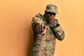 Young african american man wearing army uniform laughing at you, pointing finger to the camera with hand over mouth, shame Royalty Free Stock Photo