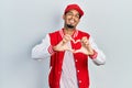 Young african american man wearing baseball uniform smiling in love doing heart symbol shape with hands