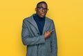 Young african american man wearing business clothes and glasses pointing aside worried and nervous with forefinger, concerned and Royalty Free Stock Photo