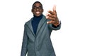 Young african american man wearing business clothes and glasses smiling friendly offering handshake as greeting and welcoming Royalty Free Stock Photo