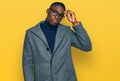 Young african american man wearing business clothes and glasses worried and stressed about a problem with hand on forehead, Royalty Free Stock Photo