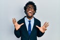 Young african american man wearing business suit celebrating mad and crazy for success with arms raised and closed eyes screaming Royalty Free Stock Photo