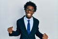 Young african american man wearing business suit very happy and excited doing winner gesture with arms raised, smiling and Royalty Free Stock Photo