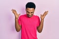 Young african american man wearing casua t shirt celebrating mad and crazy for success with arms raised and closed eyes screaming