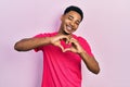 Young african american man wearing casua t shirt smiling in love doing heart symbol shape with hands