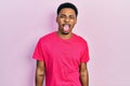 Young african american man wearing casua t shirt sticking tongue out happy with funny expression