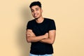 Young african american man wearing casual black t shirt happy face smiling with crossed arms looking at the camera Royalty Free Stock Photo