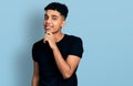 Young african american man wearing casual black t shirt smiling looking confident at the camera with crossed arms and hand on chin Royalty Free Stock Photo