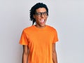 Young african american man wearing casual clothes and glasses winking looking at the camera with sexy expression, cheerful and Royalty Free Stock Photo