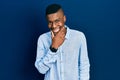 Young african american man wearing casual clothes looking confident at the camera smiling with crossed arms and hand raised on Royalty Free Stock Photo