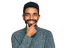 Young african american man wearing casual clothes looking confident at the camera smiling with crossed arms and hand raised on Royalty Free Stock Photo