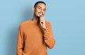 Young african american man wearing casual clothes looking confident at the camera smiling with crossed arms and hand raised on Royalty Free Stock Photo