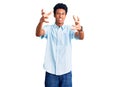 Young african american man wearing casual clothes shouting frustrated with rage, hands trying to strangle, yelling mad Royalty Free Stock Photo
