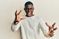 Young african american man wearing casual clothes shouting frustrated with rage, hands trying to strangle, yelling mad Royalty Free Stock Photo