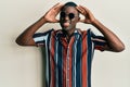 Young african american man wearing casual clothes and sunglasses with hand on head, headache because stress Royalty Free Stock Photo