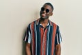 Young african american man wearing casual clothes and sunglasses looking to side, relax profile pose with natural face and Royalty Free Stock Photo