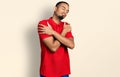 Young african american man wearing casual polo hugging oneself happy and positive, smiling confident Royalty Free Stock Photo