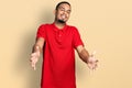 Young african american man wearing casual polo looking at the camera smiling with open arms for hug Royalty Free Stock Photo