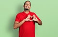Young african american man wearing casual polo smiling in love doing heart symbol shape with hands Royalty Free Stock Photo