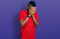 Young african american man wearing casual red t shirt with sad expression covering face with hands while crying Royalty Free Stock Photo