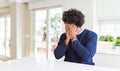 Young african american man wearing casual sweater sitting at home with sad expression covering face with hands while crying Royalty Free Stock Photo