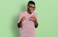 Young african american man wearing casual t shirt and glasses disgusted expression, displeased and fearful doing disgust face Royalty Free Stock Photo