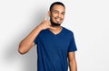 Young african american man wearing casual t shirt smiling doing phone gesture with hand and fingers like talking on the telephone Royalty Free Stock Photo