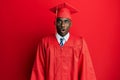 Young african american man wearing graduation cap and ceremony robe afraid and shocked with surprise expression, fear and excited Royalty Free Stock Photo